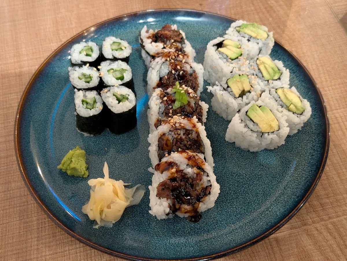 Three types of sushi rolls with wasabi and ginger