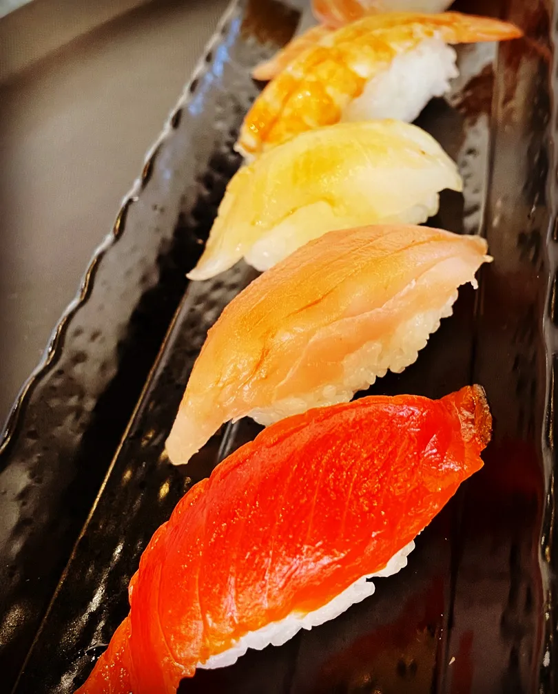 Assortment of sushi pieces on a black plate